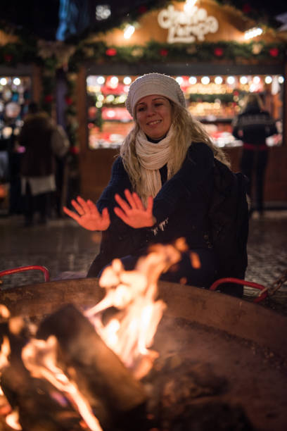 istock Young woman warming up hands to fireplace . 1048142042