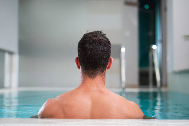 istock Man relaxing in a swimming pool at a spa 1048142256