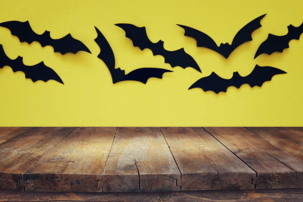 istock Halloween holiday concept. Empty rustic table in front of black bats background. Ready for product display montage. 1048142336