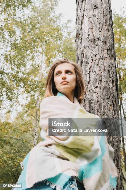 Lifestyle Portrait Of Young Adult Female Wrapped In Her Scarf In The Forest Or Park Stock Photo - Download Image Now