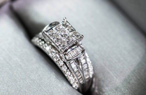 istock A diamond engagement ring in a box with glint/reflection. Shimmering princess-cut diamonds. 1048146966