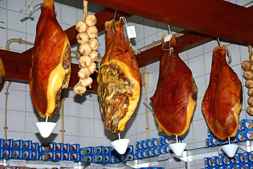 Cured legs of ham for sale in the indoor market, Olhao, Algarve, Portugal, Europe.