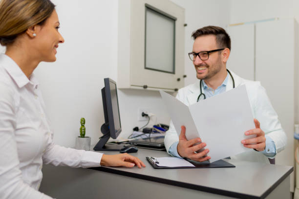 istock Handsome doctor is talking with young female patient 1048147460