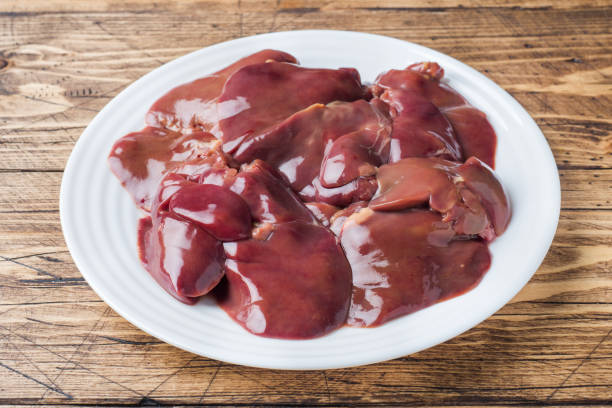 istock Fresh raw chicken liver on a plate. Wooden rustic background 1048170240