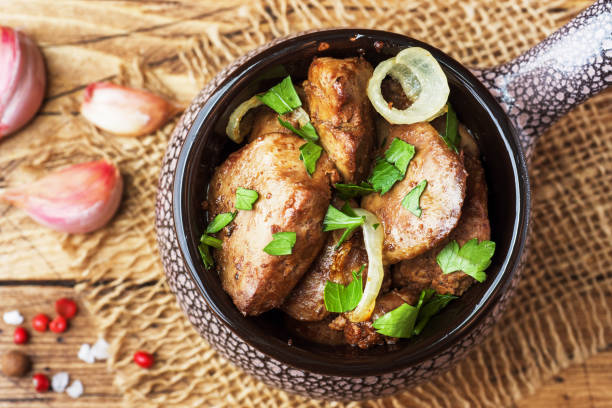 istock Baked chicken liver with onion in a ceramic cocotte on a wooden rustic table. 1048171722