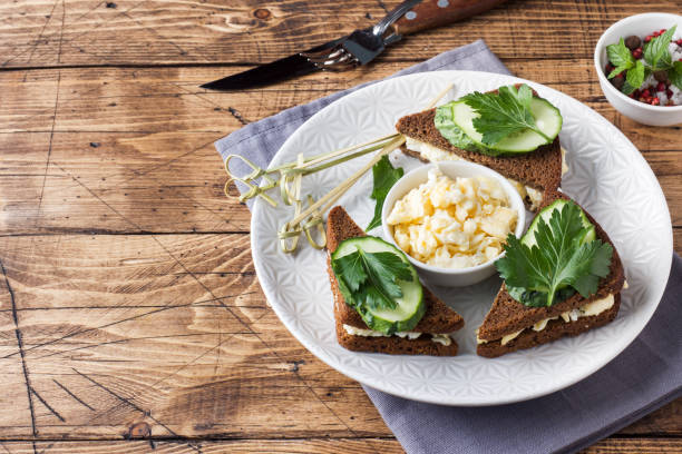istock Sandwich with scrambled eggs, cucumbers and parsley on wooden rustic background. 1048176164