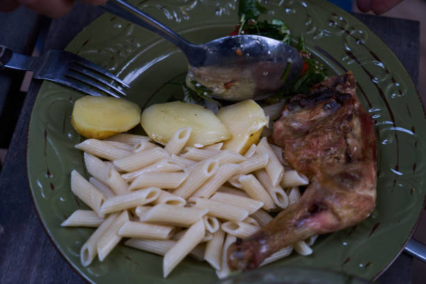 istock Baked chicken legs with penne pasta on a green plate 1048182876