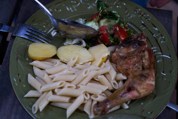istock Baked chicken legs with penne pasta on a green plate 1048182886
