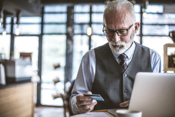 istock Senior businessman using laptop to check credit card . 1048184110