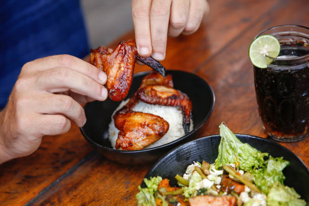 Young men eating barbecue chicken wings