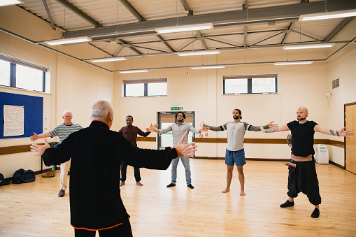 Diverse group of men are taking part in Tai Chi therapy class.