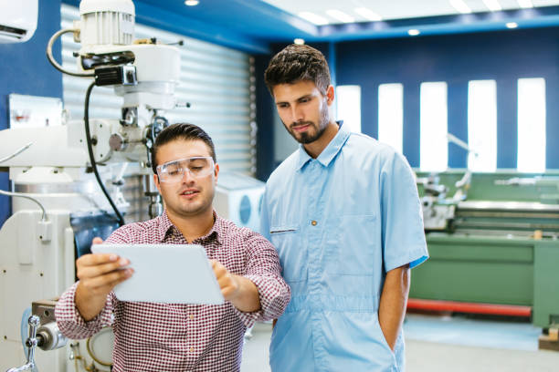 istock Latin engineers reading from tablet in shop 1048191414