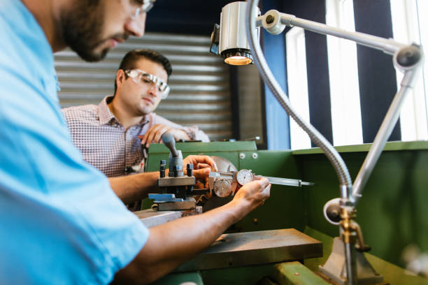 istock Engineers working on lathe in the shop 1048193318