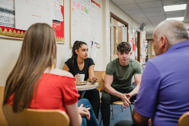 Teenagers Group Therapy at the Community Centre Small group o teenagers are talking to a mental health professional in a support group at the community centre. teenagers only teenager multi ethnic group student stock pictures, royalty-free photos & images