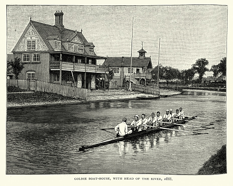 Vintage engraving of Rowers going passed Goldie Boathouse, 19th Century. Goldie Boathouse is the fitness and administrative base of Cambridge University Boat Club (CUBC), located on the river Cam in Cambridge, England.  It was originally the University boathouse and was named after CUBC's President J. H. D. Goldie