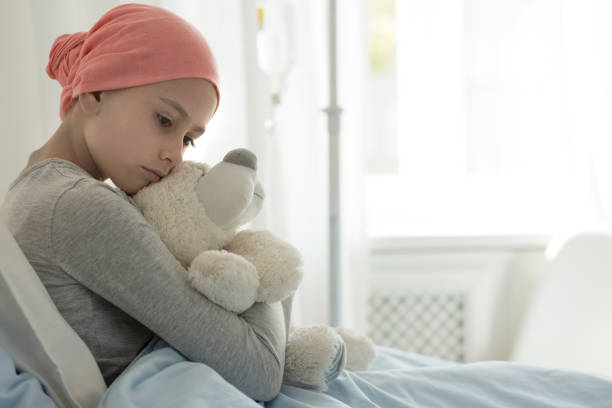 Weak girl with cancer wearing pink headscarf and hugging teddy bear Weak girl with cancer wearing pink headscarf and hugging teddy bear cancer illness stock pictures, royalty-free photos & images