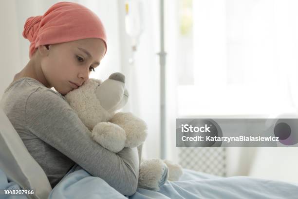 Weak Girl With Cancer Wearing Pink Headscarf And Hugging Teddy Bear Stock Photo - Download Image Now