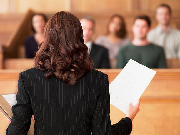 Lawyer holding document and speaking to jury in courtroom  court room stock pictures, royalty-free photos & images