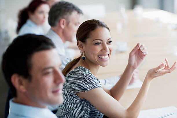 empresária sorridente balançando um bastão em reunião na sala de conferências - persuasion - fotografias e filmes do acervo