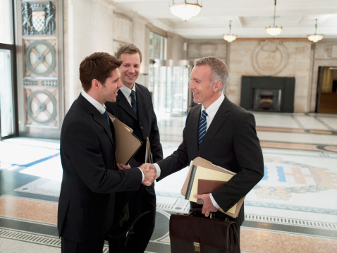 Shot of two businesspeople shaking hands while having a standing in an office