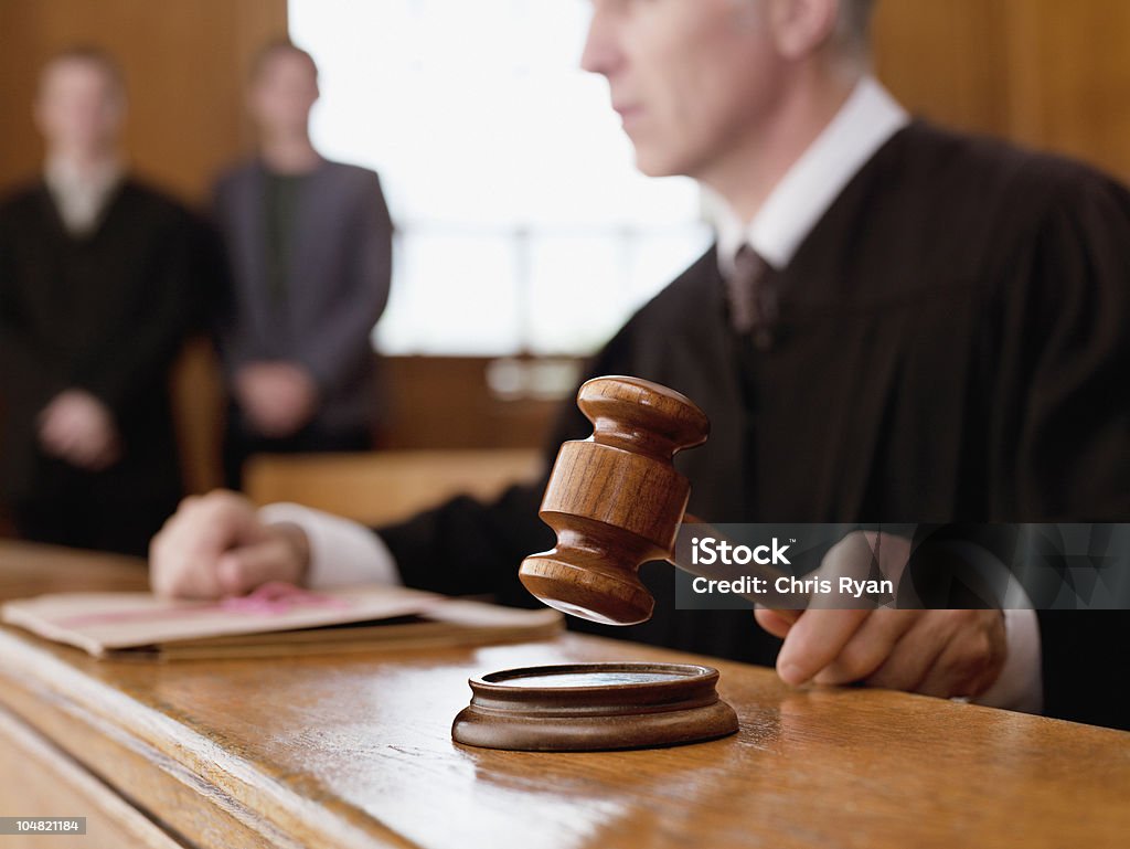 Judge holding gavel in courtroom  Courthouse Stock Photo