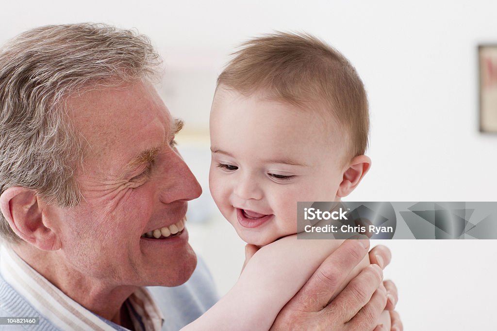 Pie de bebé sonriente sosteniendo - Foto de stock de Abuelo libre de derechos