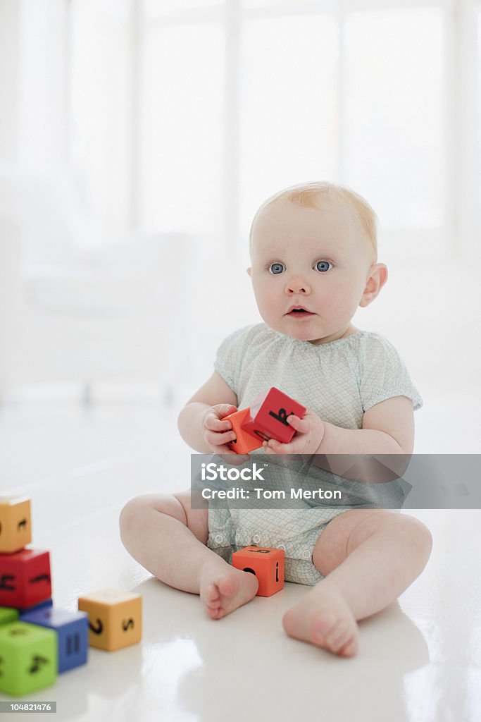 Curioso bebê no chão brincando com blocos de Madeira - Royalty-free Bebé Foto de stock