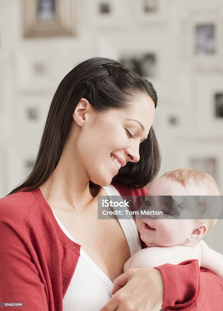 Sonriente bebé madre sostiene - Foto de stock de Agarrar libre de derechos