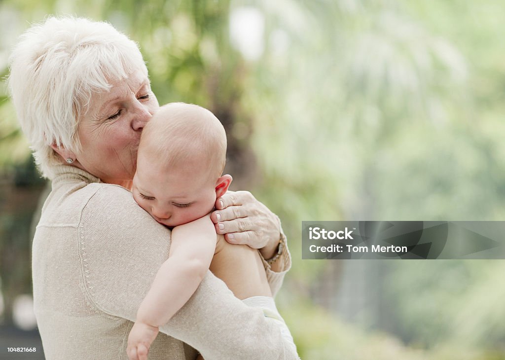 Grand-mère tenant et Embrasser bébé - Photo de Bébé libre de droits