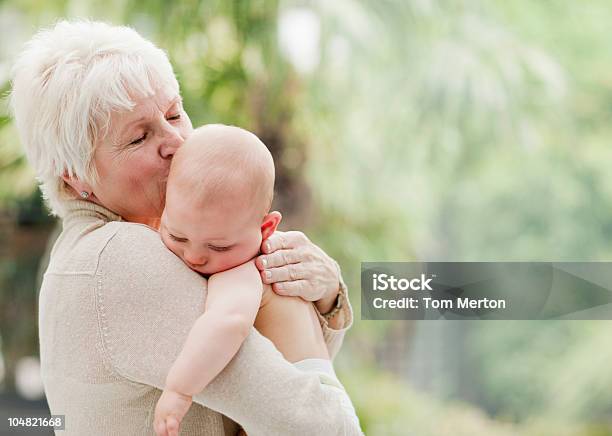 Nonna Holding E Baciare Bambino - Fotografie stock e altre immagini di Bebé - Bebé, Nonna, Donne anziane