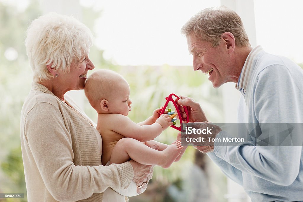 Dziadków gospodarstwa dziecka z zabawka - Zbiór zdjęć royalty-free (Babka - Dziadek i babcia)