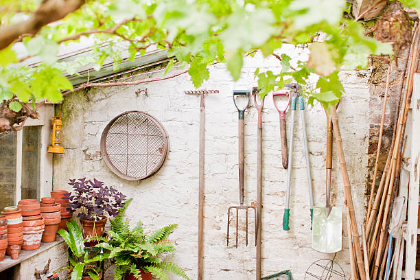 strumenti giardino appeso sulla parete dello shed - baracca foto e immagini stock