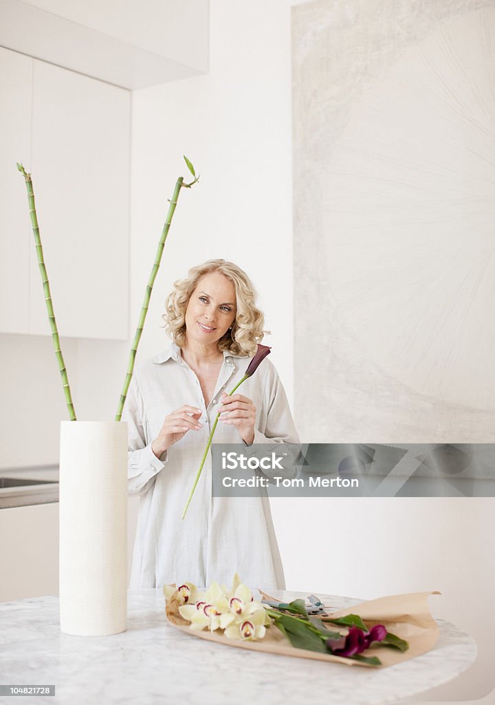 Улыбающаяся женщина заказать цветы в Ваза - Стоковые фото Бамбук роялти-фри
