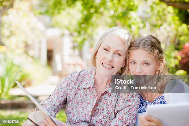 Photo libre de droit de Souriant De Grandmère Et Petitefille Tenant Blocnotes banque d'images et plus d'images libres de droit de Londres