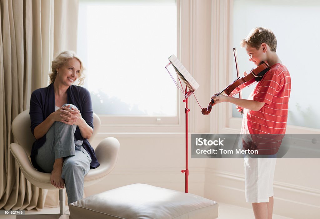 Mulher sorridente assistindo filho brincar violino - Foto de stock de Violino royalty-free