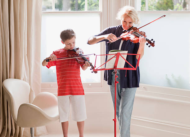 mujer y niño tocando violín - violin family fotografías e imágenes de stock