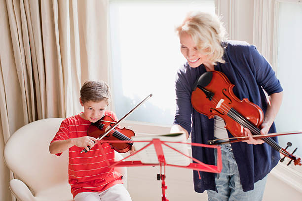 donna e ragazzo suona il violino - music listening child smiling foto e immagini stock