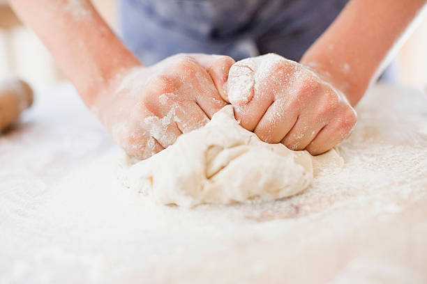 primer plano de niña masa de amasado - makes the dough fotografías e imágenes de stock