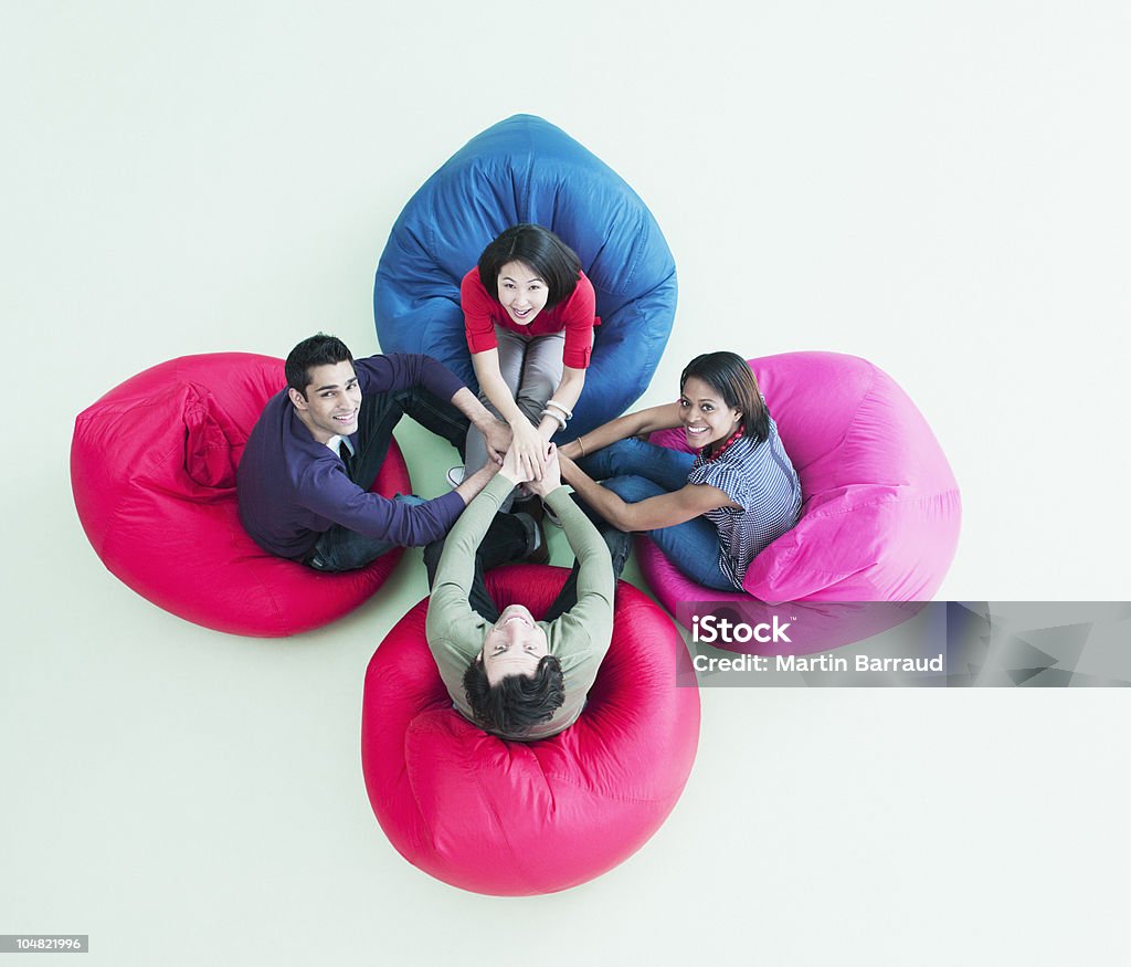 Sorridente uomini d'affari seduti in Cuscinone sedie con logo - Foto stock royalty-free di Lavoro di squadra