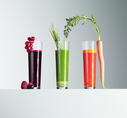 Fresh beetroot juice in a glass cup with red apples, top view