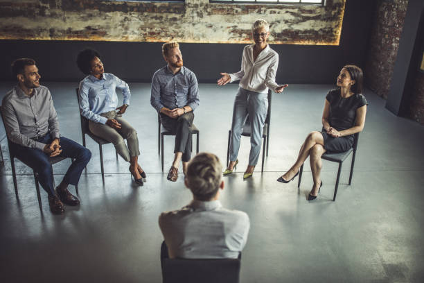 istock Happy senior businesswoman presenting herself on a group therapy. 1048221212