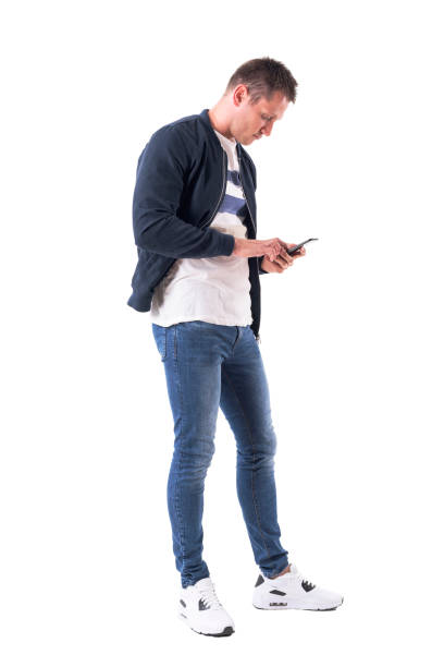 istock Side view of young casual man typing message on mobile phone. 1048223174