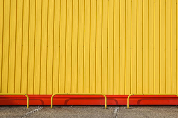 istock yellow metal panel construction, wall of building with blue sky. 1048227320