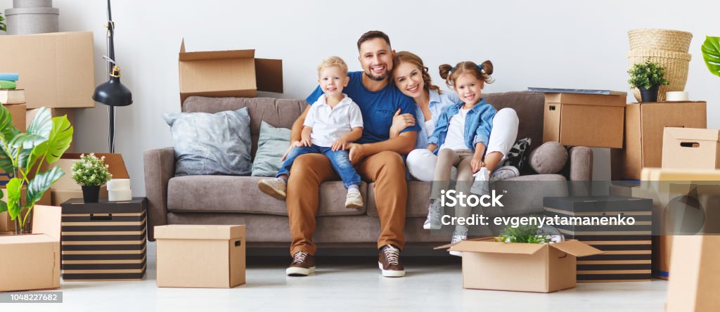 niños y padre de la feliz madre de familia pasar a nuevo apartamento y Desempaque de cajas - Foto de stock de Familia libre de derechos