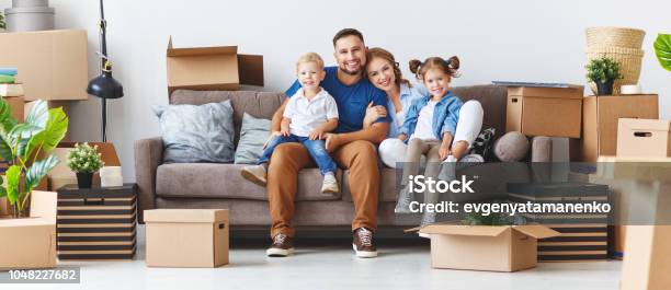 Happy Family Mother Father And Children Move To New Apartment And Unpack Boxes Stock Photo - Download Image Now