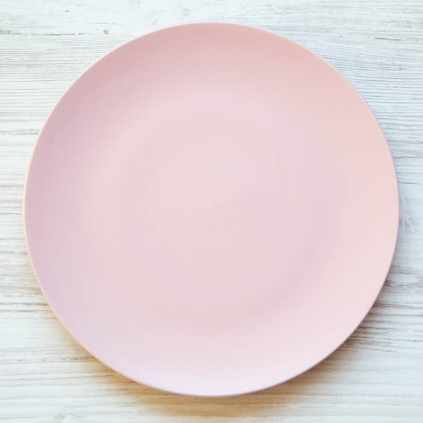 istock Empty pink plate on a white wooden table, overhead view. Top view, from above, flat lay. Dieting concept. 1048237668