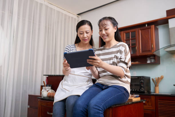 istock Women Watching Cooking Video 1048238172