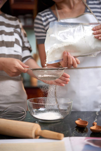 istock Women Sieving Flour 1048238188