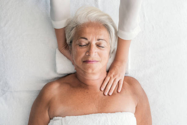 mulher recebendo massagem de pescoço - relaxation lying on back women meditating - fotografias e filmes do acervo