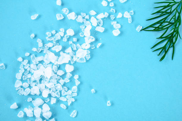 istock Crystals of large sea salt and dill on a blue table. 1048248968
